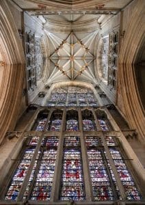 a huge stained glass window and the ornate roof of a cathedral