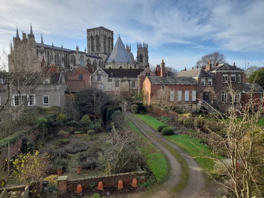 a photo overlooking somepleasant gardens and houses, with York Minster rising in the background